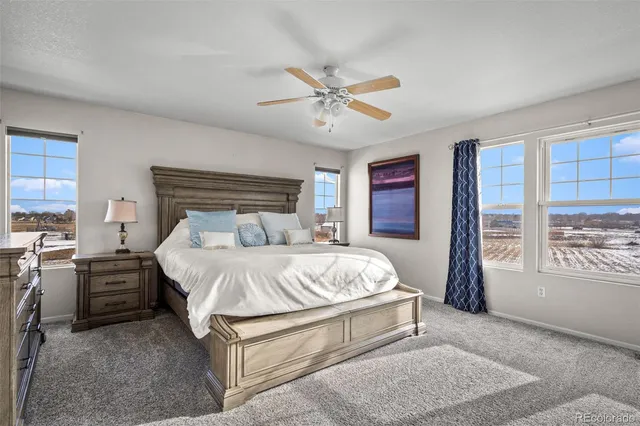 a bed sitting in a spacious bedroom next to a window