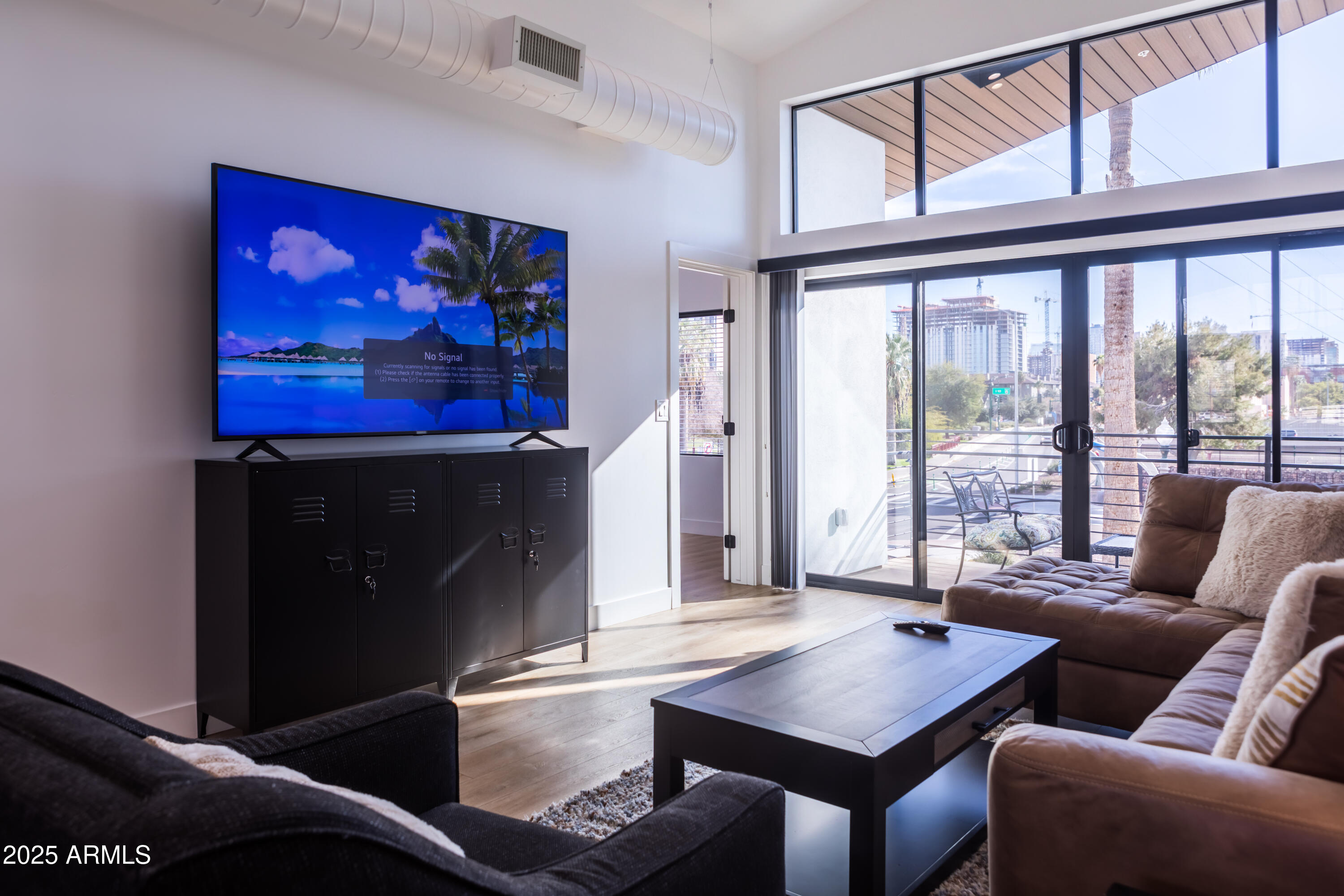 302 West Culver Street, Unit 3 Phoenix, AZ 85003 - Photo 8 of 21 a living room with furniture a flat screen tv and a floor to ceiling window