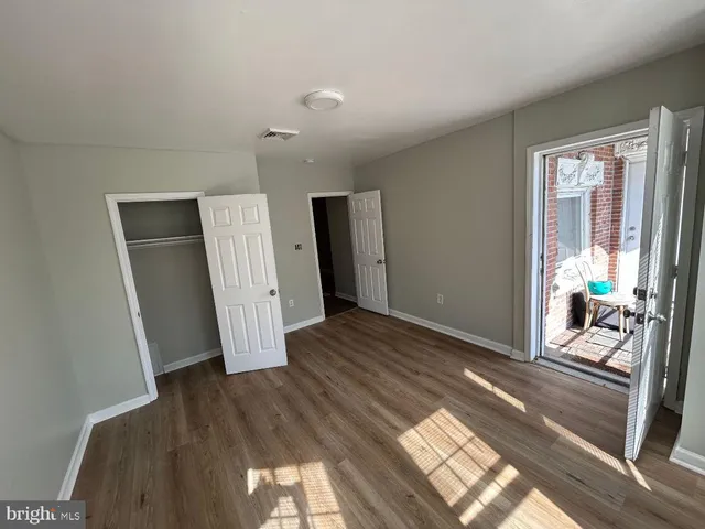 a view of a big room with wooden floor and windows