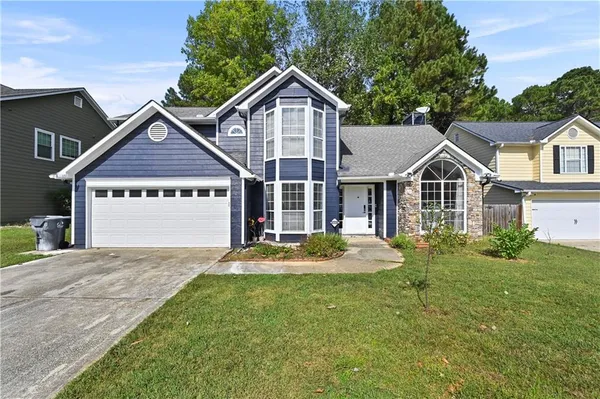 a front view of a house with a yard and garage