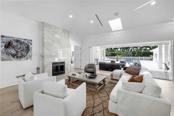 a living room with furniture a fireplace and a floor to ceiling window