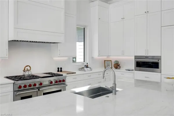 a kitchen with granite countertop a sink a stove and cabinets