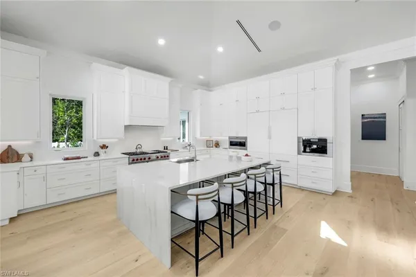 a kitchen with white cabinets and stainless steel appliances