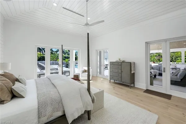 a bedroom with a bed couch and a large window