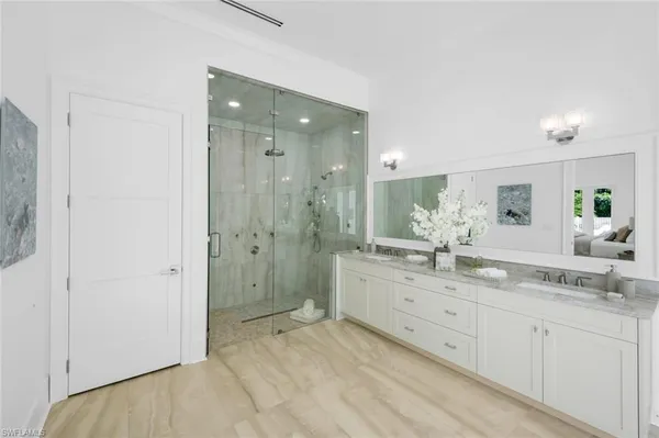 a spacious bathroom with a granite countertop sink mirror and shower