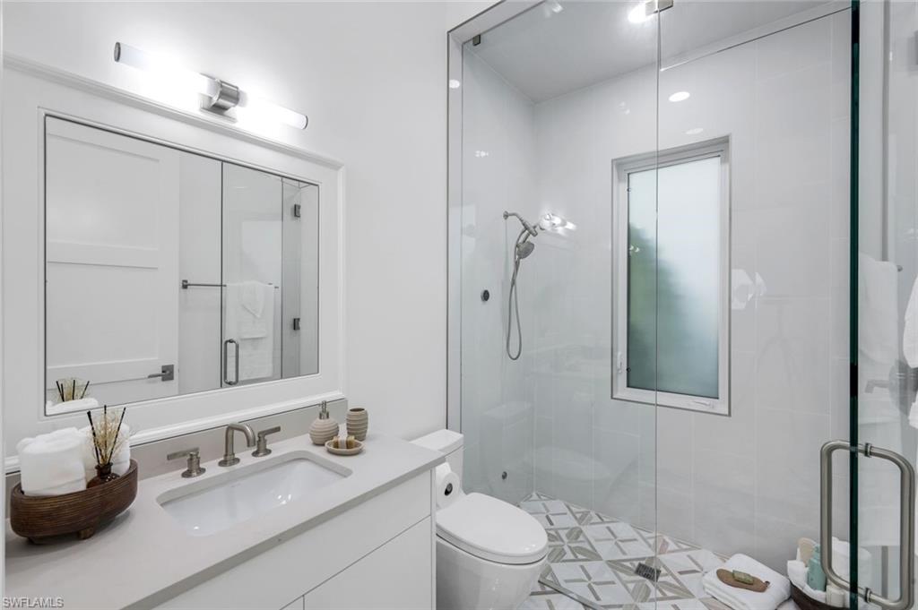 3136 Ravenna Avenue Naples, FL 34120 - Photo 38 of 50 a bathroom with a granite countertop sink toilet and shower