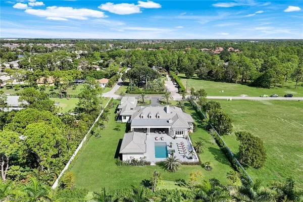 an aerial view of residential houses with outdoor space and trees