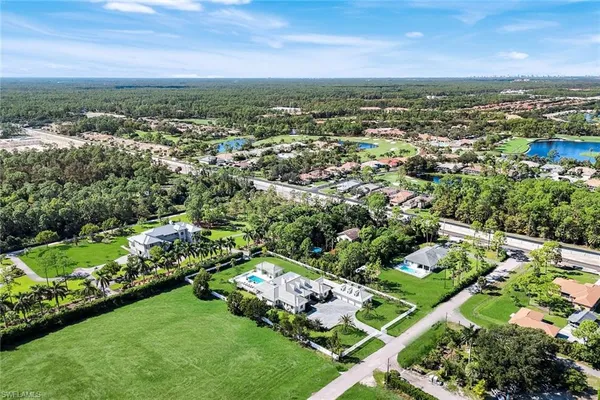 an aerial view of residential houses with outdoor space and trees