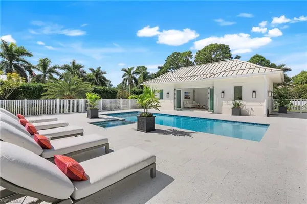 a view of a patio with couches and table and chairs with wooden fence
