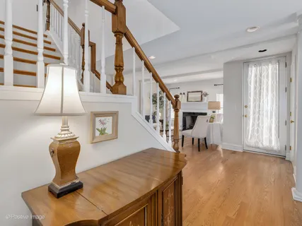 a kitchen with stainless steel appliances granite countertop a dining table chairs refrigerator and cabinets