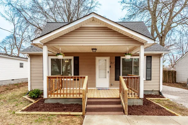 a view of front a house with a small yard and large tree