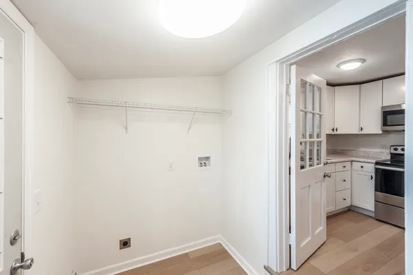 a kitchen with white cabinets and white appliances