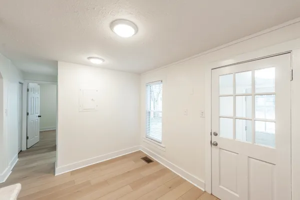 an empty room with wooden floor and windows