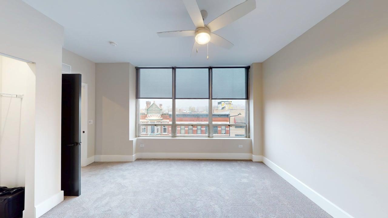 40 Dupage Court, Unit 309 Elgin, IL 60120 - Photo 15 of 18 an empty room with chandelier fan and windows