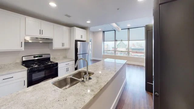 a kitchen with stainless steel appliances granite countertop a sink stove and refrigerator
