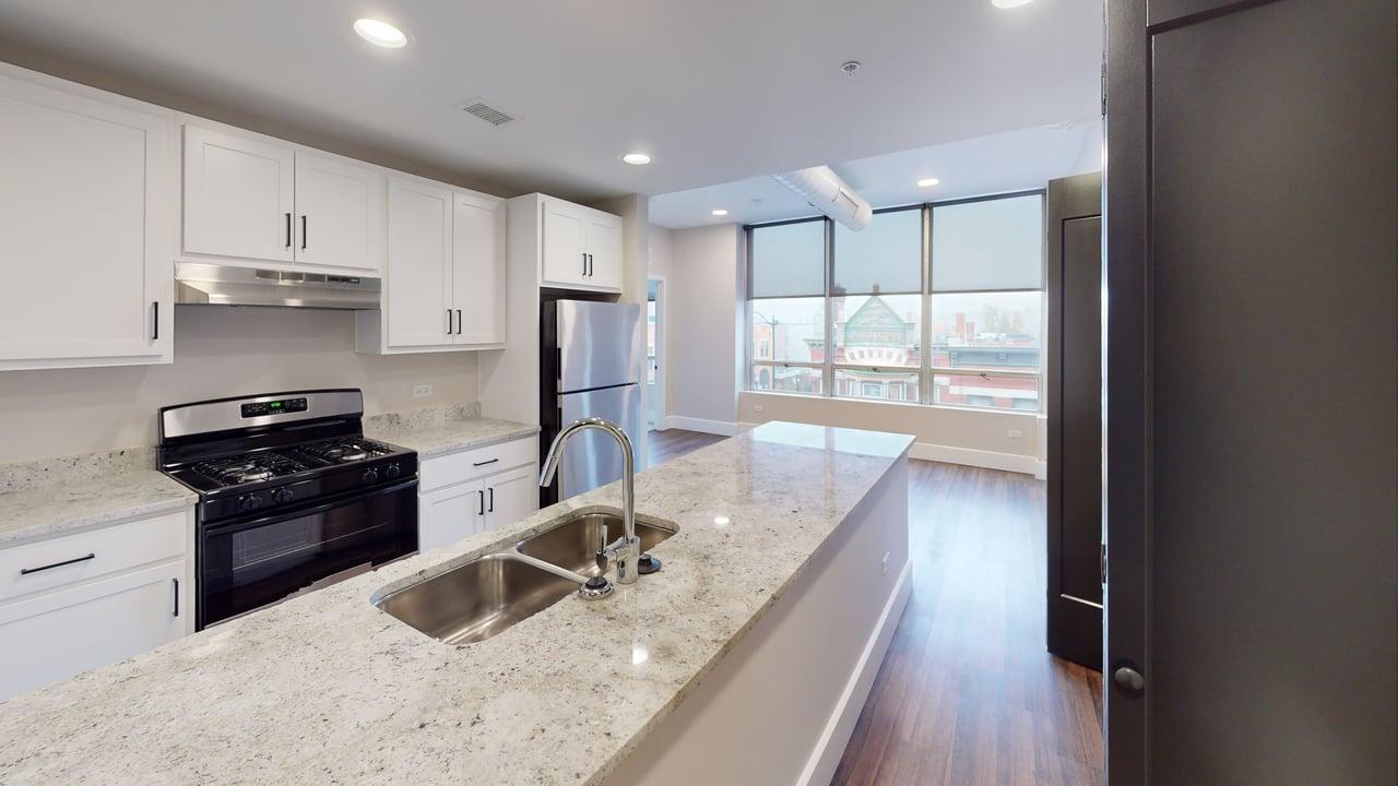 40 Dupage Court, Unit 309 Elgin, IL 60120 - Photo 8 of 18 a kitchen with granite countertop a stove sink and refrigerator
