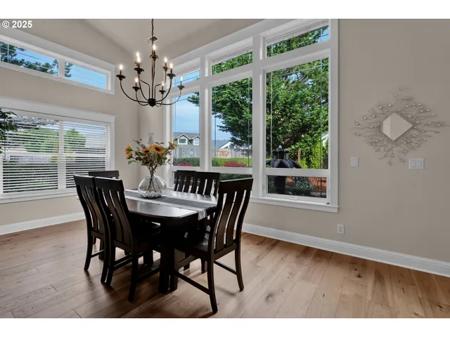a view of a dining room with furniture a chandelier and wooden floor