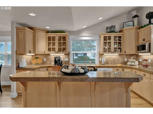a kitchen with kitchen island granite countertop a sink and a counter top space