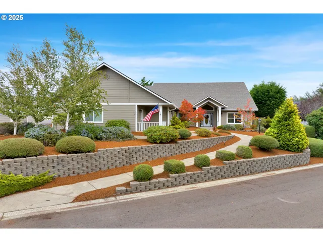 a front view of house with yard and trees in the background