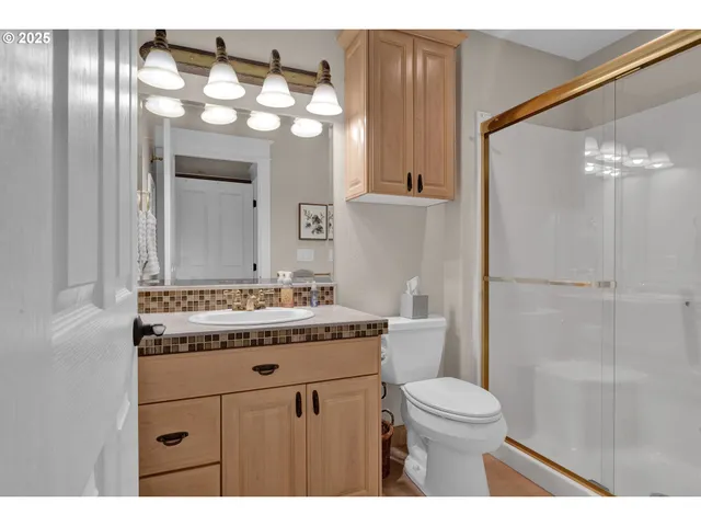 a bathroom with a granite countertop sink toilet a mirror and shower