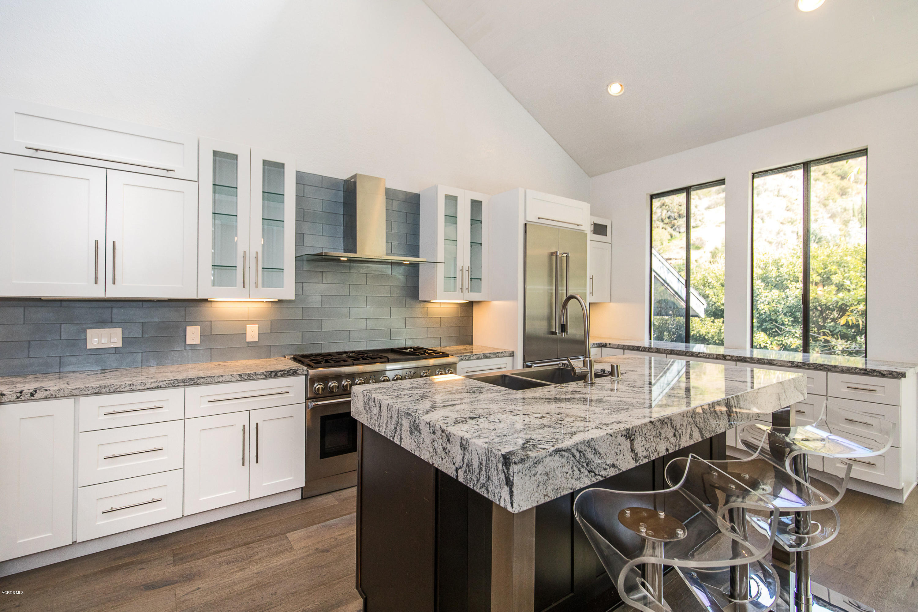 2001 Roscomare Road Los Angeles, CA 90077 - Photo 13 of 52 a kitchen with granite countertop kitchen island wooden cabinets and dining table
