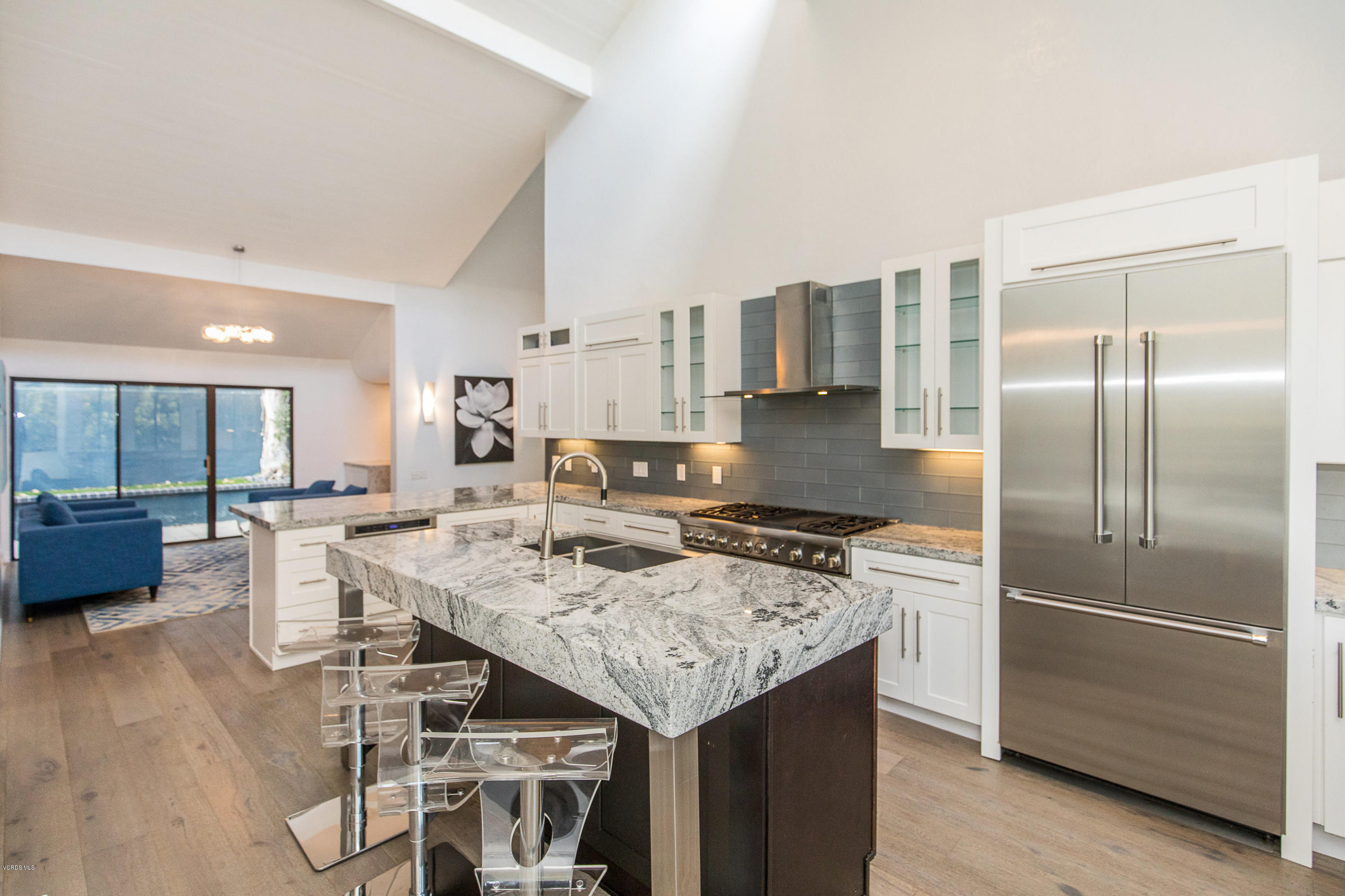 2001 Roscomare Road Los Angeles, CA 90077 - Photo 14 of 52 a kitchen with a refrigerator a stove a sink and a dining table with wooden floor