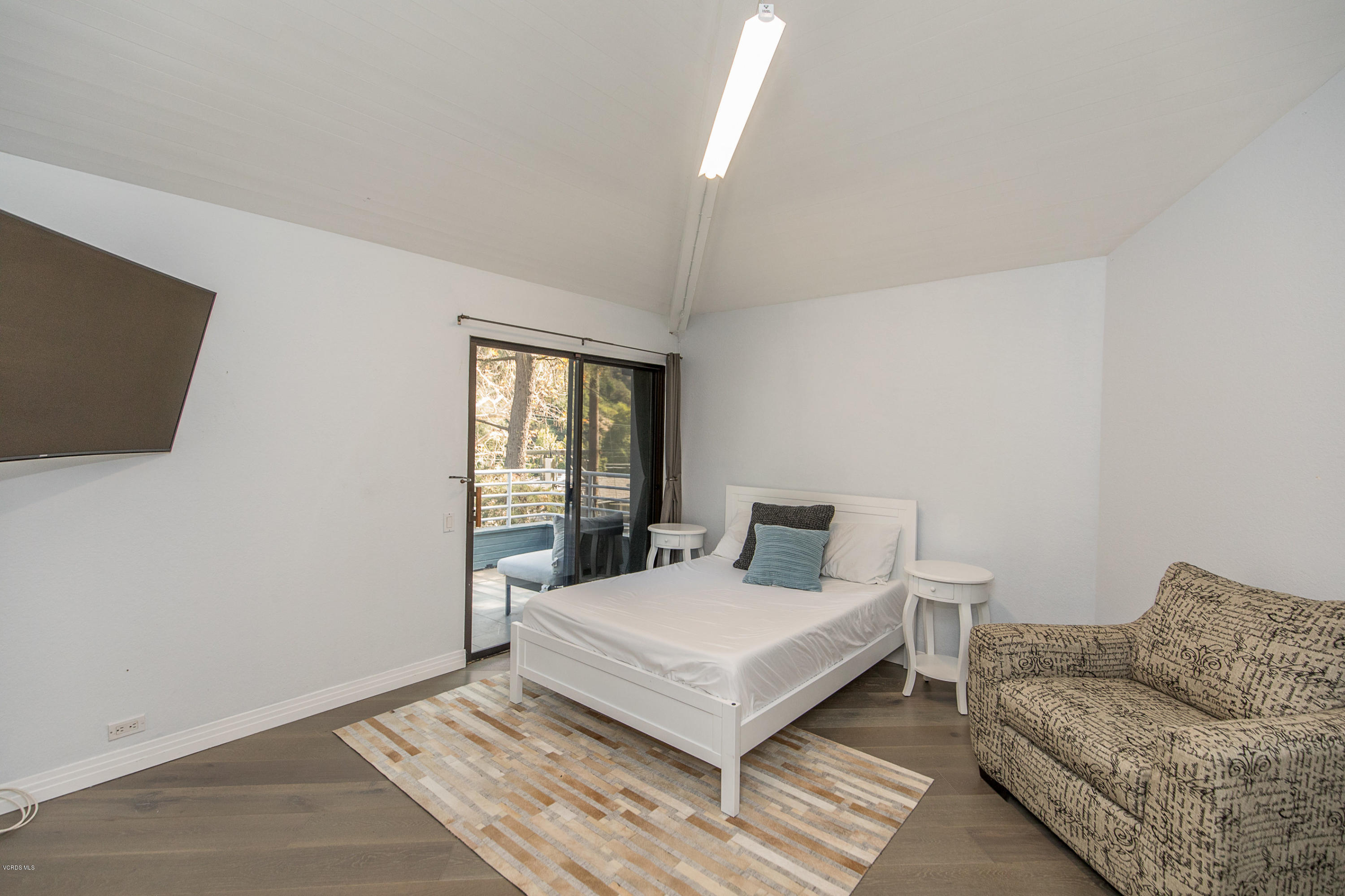 2001 Roscomare Road Los Angeles, CA 90077 - Photo 23 of 52 a living room with furniture and a flat screen tv