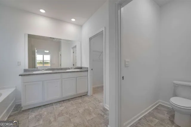 a bathroom with a granite countertop sink two mirror and a bathtub