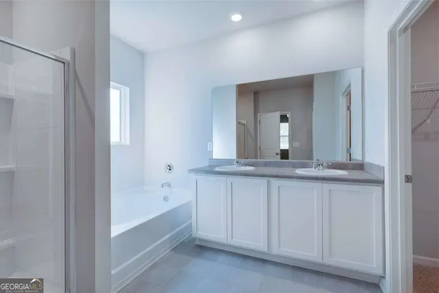 a bathroom with a granite countertop sink mirror and a bathtub