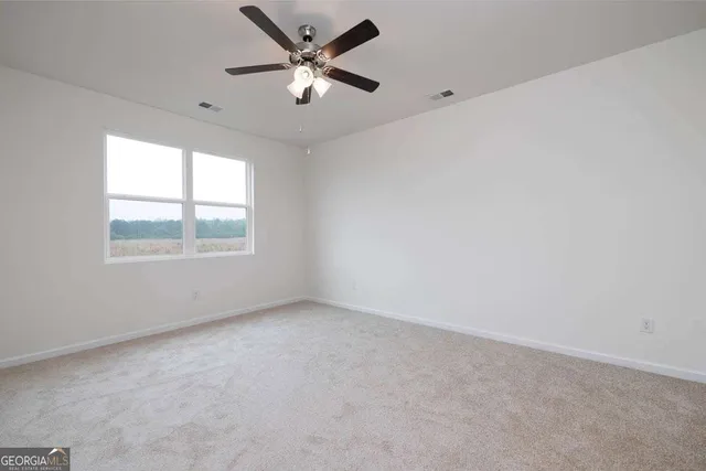 a view of an empty room and a ceiling fan