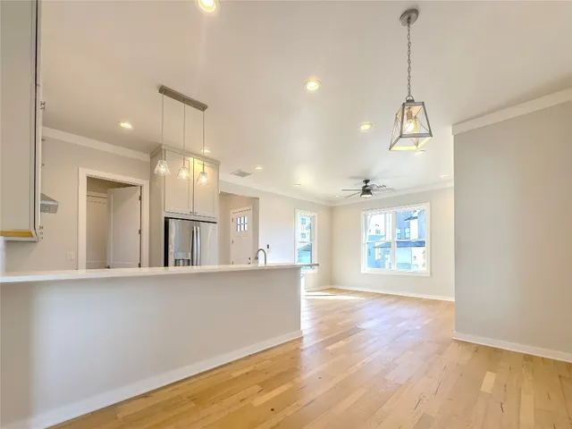 a view of a kitchen with wooden floor and windows