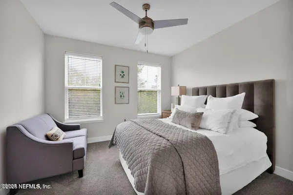 a bedroom with bed couch and window