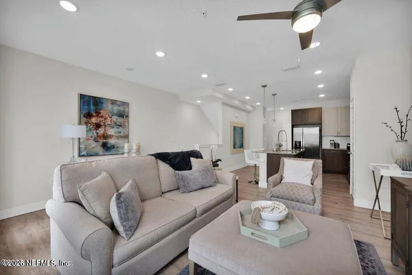 a living room with furniture and a view of kitchen
