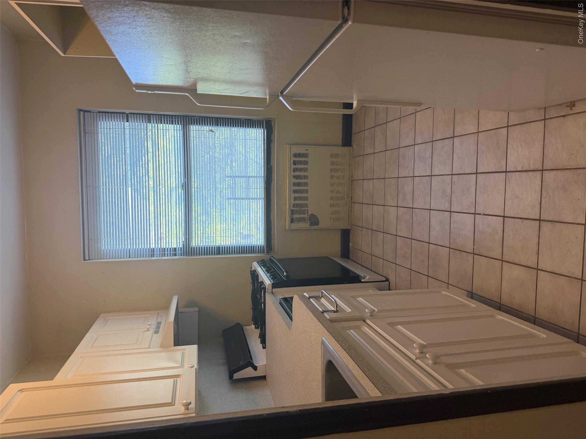 99-32 66th Road, Unit 3AA Queens, NY 11374 - Photo 4 of 9 a kitchen with a cabinets and window