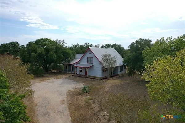 an aerial view of a house with trees in the background
