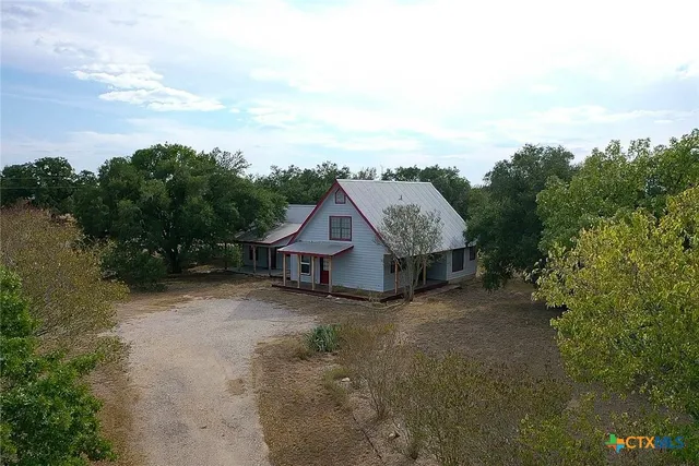 an aerial view of a house with trees in the background