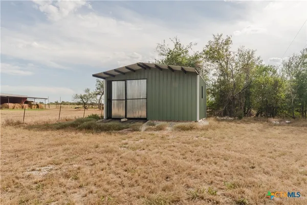 a view of a field with trees in the background