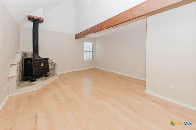a view of empty room with kitchen and window