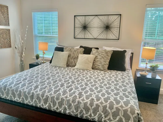 a bedroom with a bed and painting on the wall