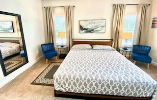 a large bed sitting in a bedroom next to a window