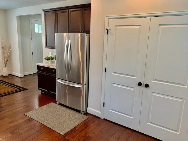 a view of a refrigerator in kitchen and wooden floor