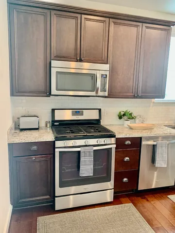 a kitchen with stainless steel appliances granite countertop a stove and a microwave