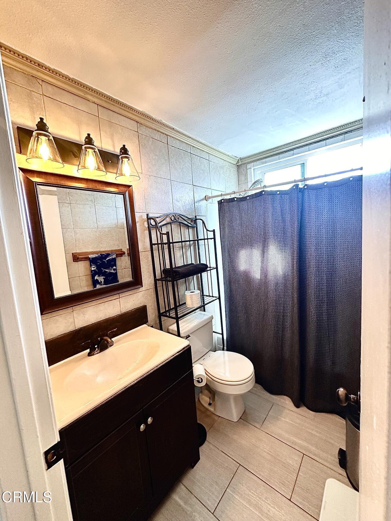 5212 Jefferson Square Oxnard, CA 93033 - Photo 7 of 12 a bathroom with a sink a toilet a mirror and shower