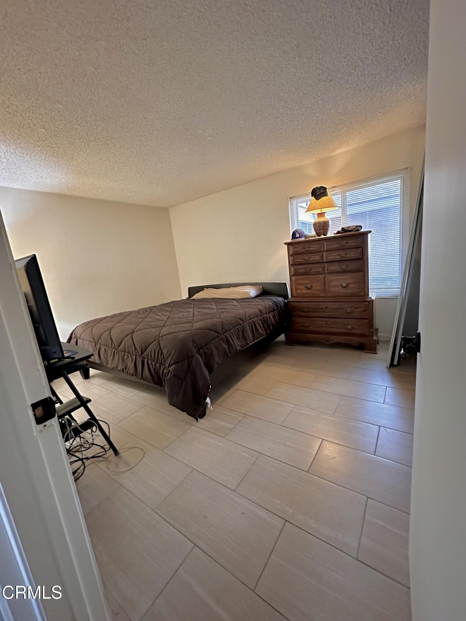 5212 Jefferson Square Oxnard, CA 93033 - Photo 9 of 12 a bedroom with a bed and a window