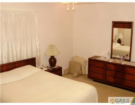 48 Woodbrook Road Edison, NJ 08820 - Photo 5 of 11 a bedroom with a bed and a dresser