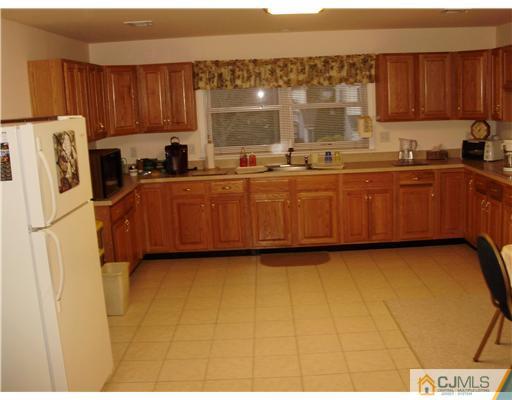 48 Woodbrook Road Edison, NJ 08820 - Photo 8 of 11 a kitchen with kitchen island granite countertop a sink cabinets and stainless steel appliances