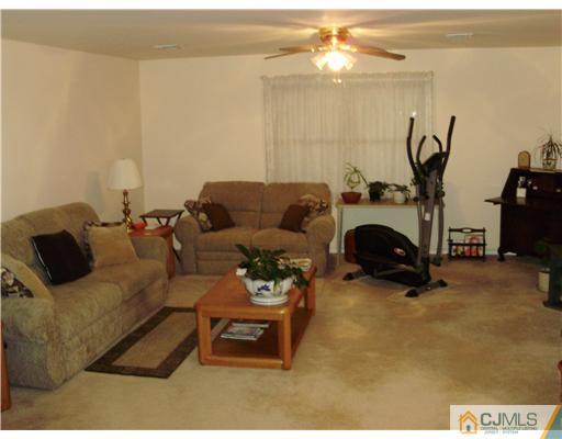 48 Woodbrook Road Edison, NJ 08820 - Photo 9 of 11 a living room with furniture a table and a chandelier