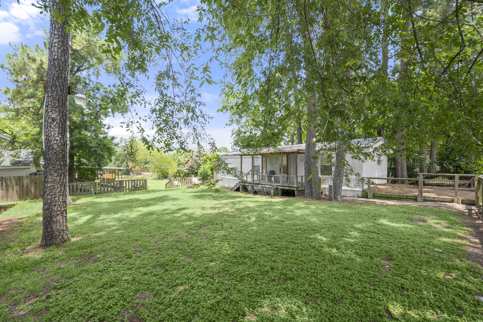 9649 Warm Spring Willis, TX 77318 - Photo 10 of 30 A verdant lawn frames this inviting dwelling, offering a serene outdoor retreat.
