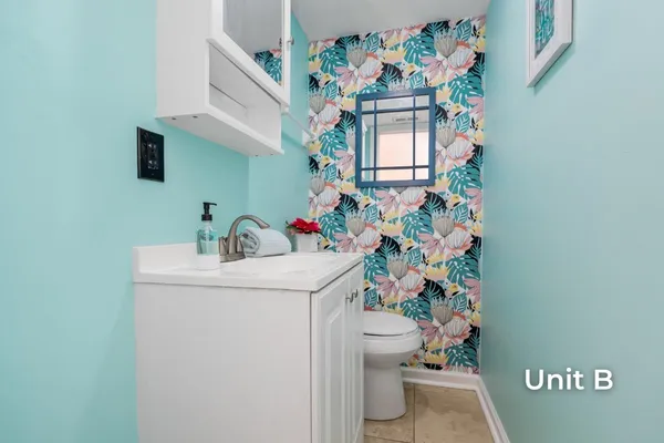 a kitchen with granite countertop a refrigerator a sink dishwasher and white cabinets with wooden floor