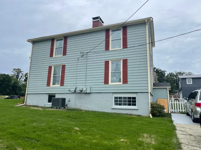 a view of a livingroom with furniture wooden floor a flat screen tv and windows